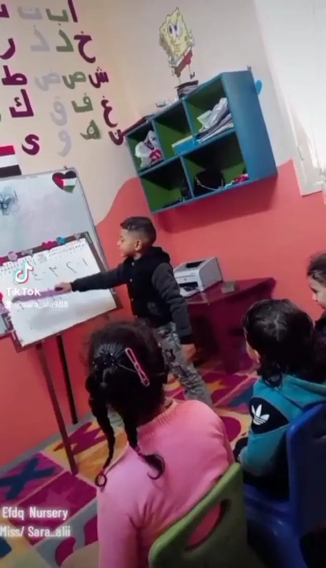 Children writing and reading at the whiteboard